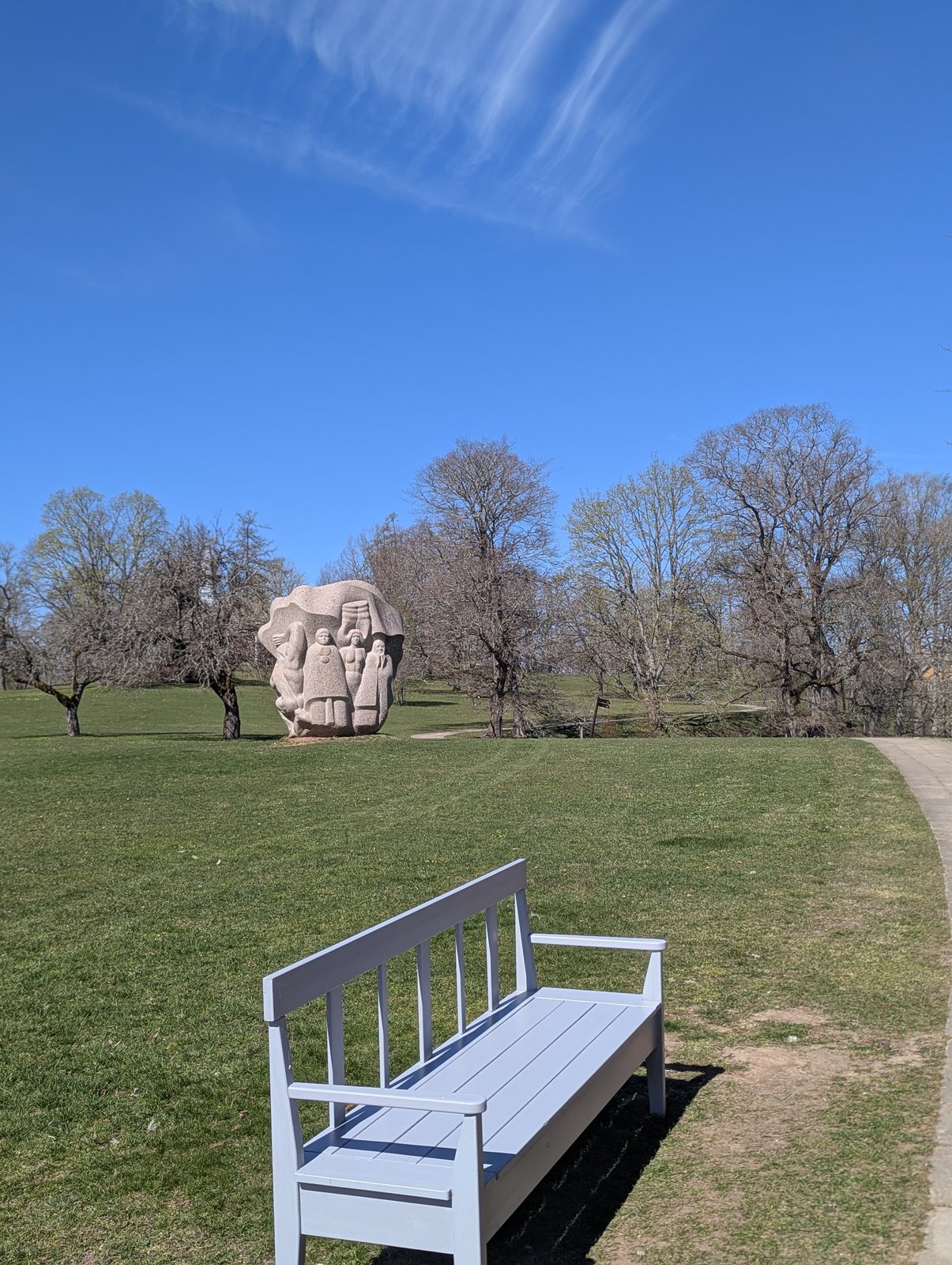 Una escultura de granito y un banco en Dainu Kalns, la Colina de las Dainas en Turaida