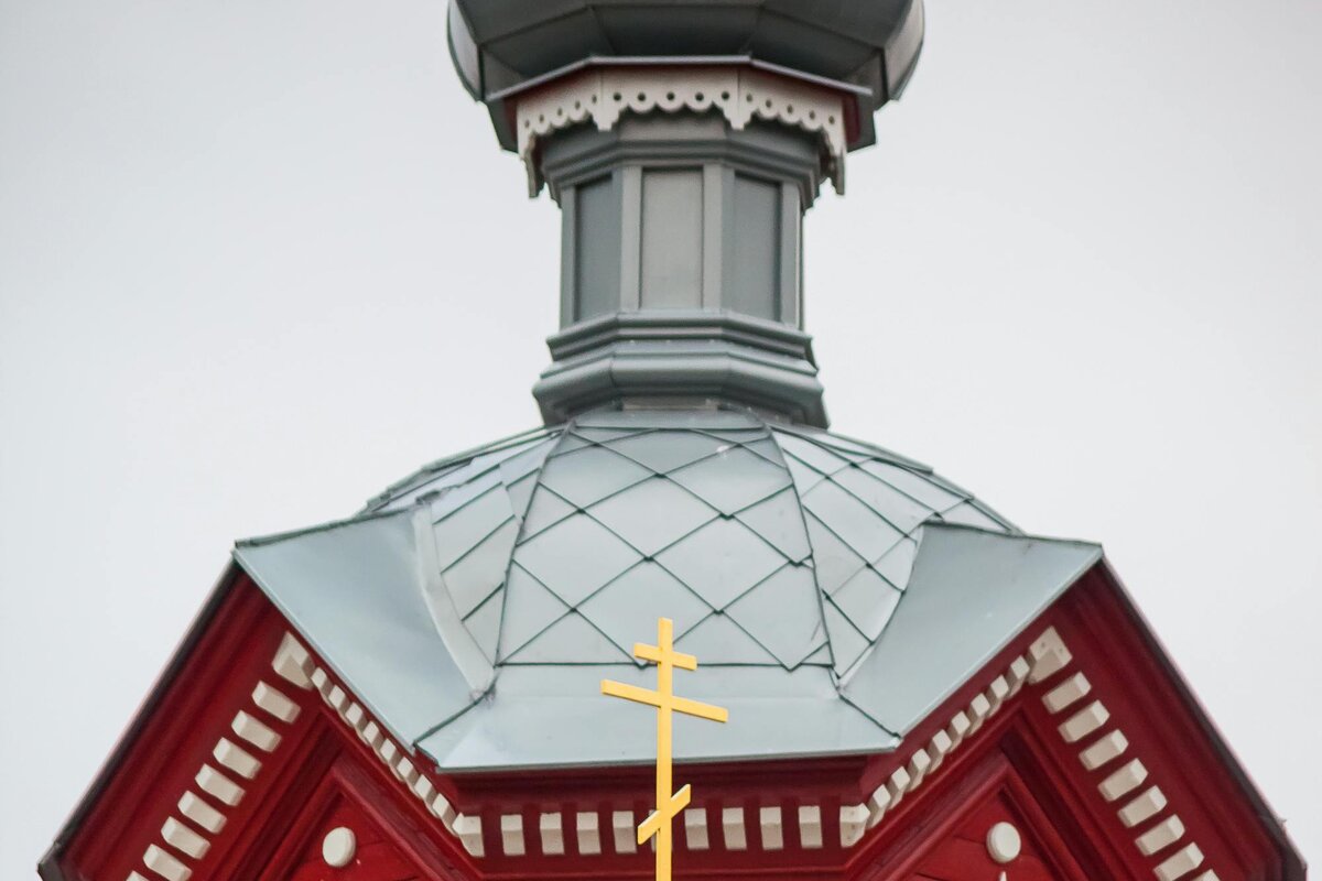 Una iglesia ortodoxa de madera con cúpula de cebolla y la cruz ortodoxa de ocho puntas y tres barras &mdash; Letonia.