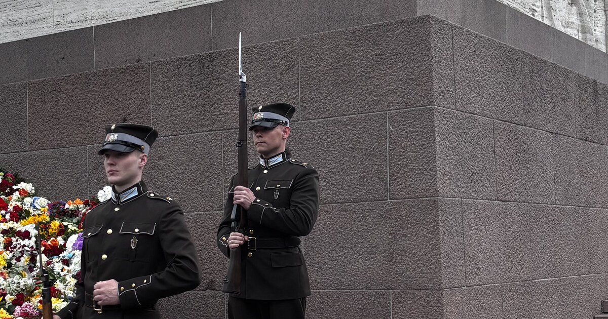 Guardia de honor del Ejército Letón en el Monumento de la Libertad con un muro de flores depositadas contra la base, Riga, en el Día de la Restauración de la Independencia