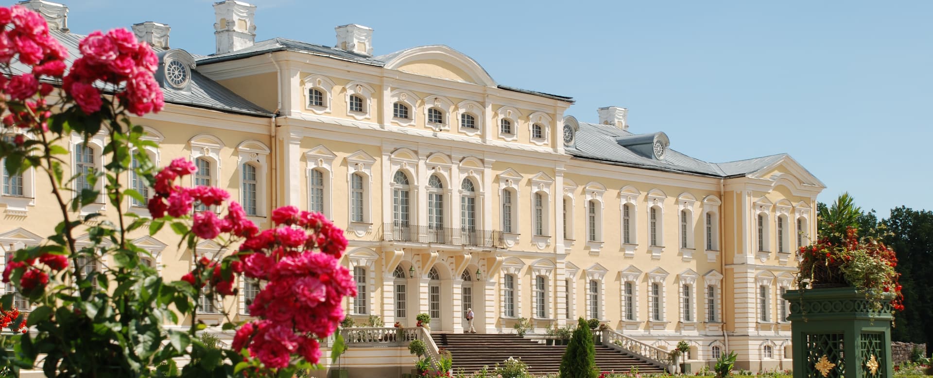 Fachada barroca del palacio de Rundāle enmarcada por los rosales en verano