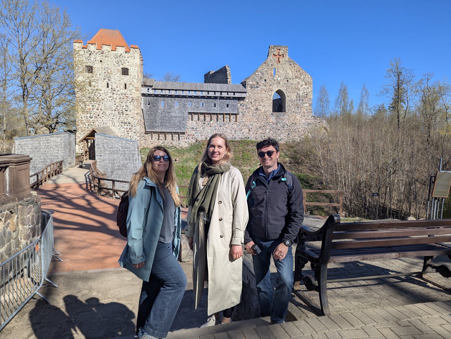 Huéspedes de Barefoot Baltic posando frente a las ruinas del castillo medieval en Sigulda