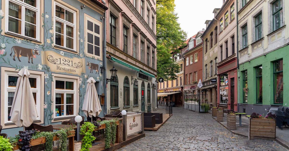 Calle adoquinada con restaurantes en el casco antiguo de Riga, Letonia.